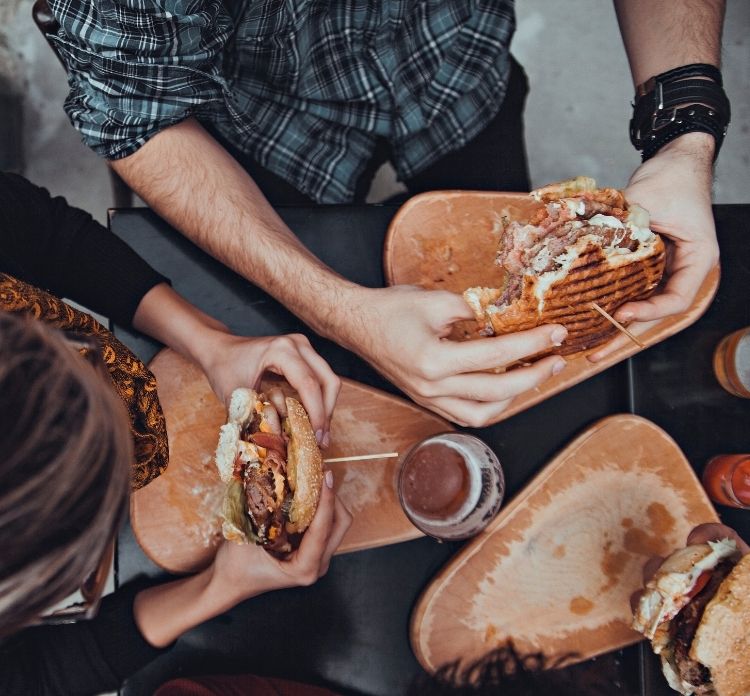 Clienti che mangiano hamburger attività di ristorazione